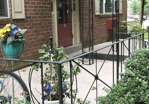 Entrance to a residential building with a porch and flowers at 韦斯特盖特的手臂 bbin出租